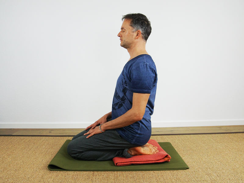 Yoga Sitzhaltung Vajrasana mit decke als Unterstützung - Meditationssitz